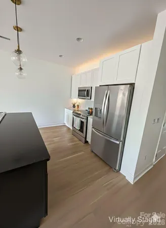 a kitchen with stainless steel appliances a refrigerator a stove a sink and a refrigerator