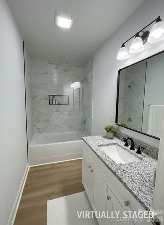 a bathroom with a granite countertop sink mirror and bathtub