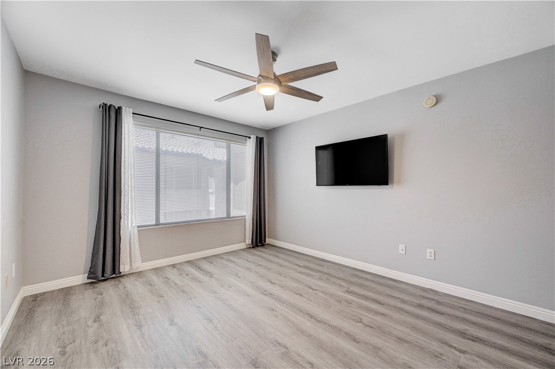 3425 East Russell Road, Unit 223 Las Vegas, NV 89120 - Photo 22 of 47 A well-lit bedroom features durable laminate flooring and a ceiling fan for comfort.