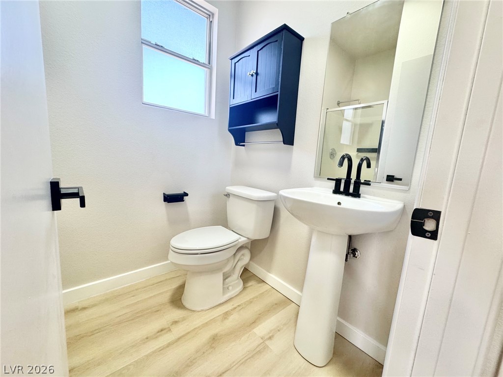 7340 Ridge Star Court Las Vegas, NV 89131 - Photo 14 of 22 A well-appointed lavatory featuring a pedestal sink and modern fixtures, complemented by a window providing natural light.
