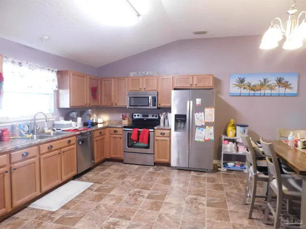 a kitchen with stainless steel appliances granite countertop a refrigerator sink and cabinets
