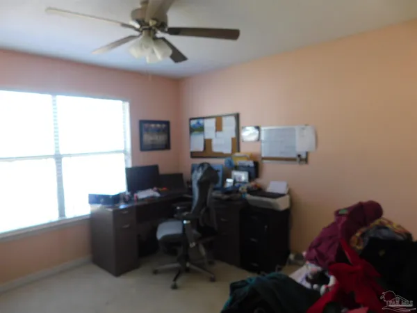 a view of a workspace with furniture and a window