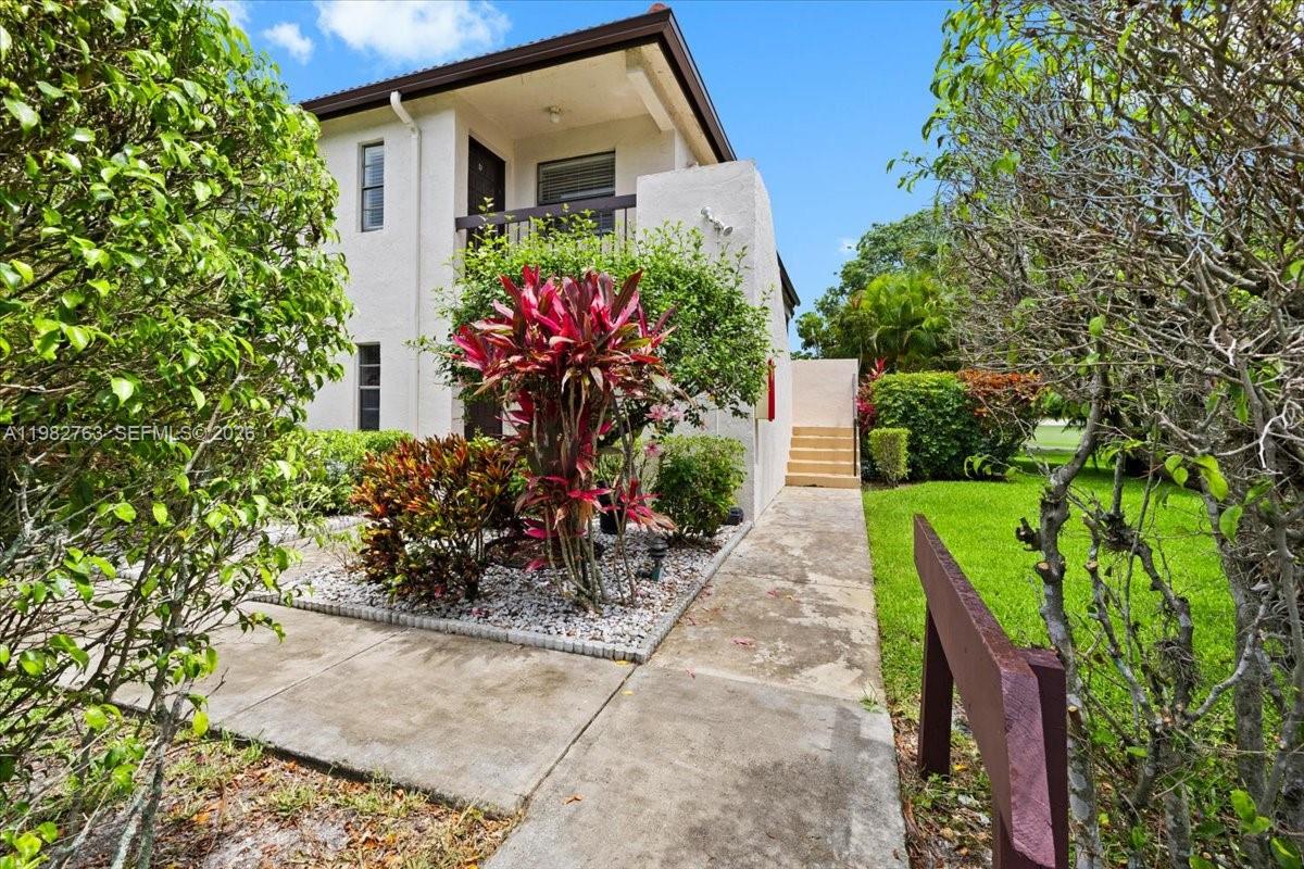 7944 Eastlake Drive, Unit D Boca Raton, FL 33433 - Photo 3 of 29 a front view of a house with a yard and fountain