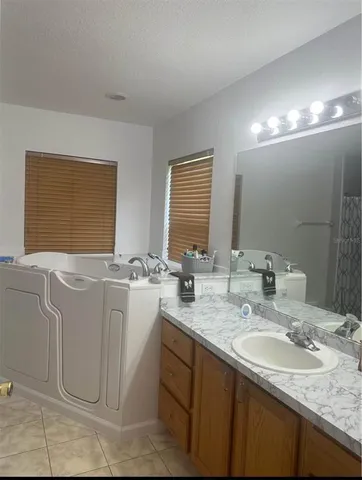 a bathroom with double vanity and a mirror