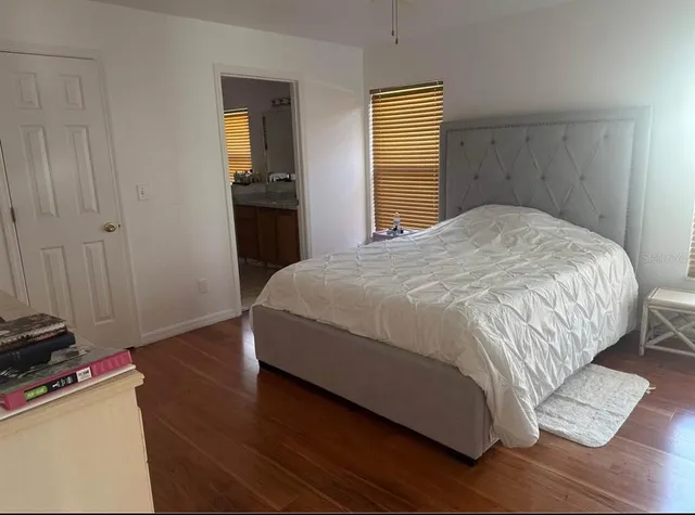 a bedroom with a bed and wooden floor