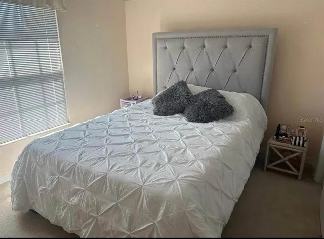 a bed sitting in a bedroom next to a window