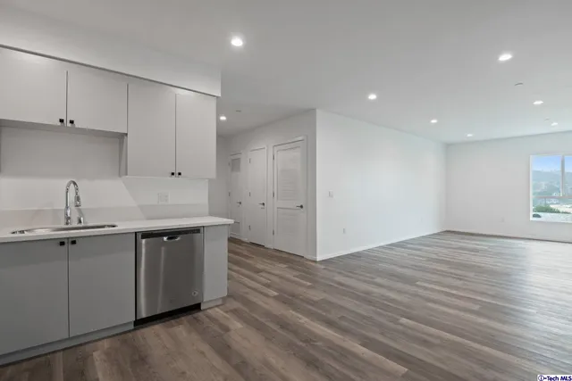 a kitchen with cabinets stainless steel appliances and a counter space
