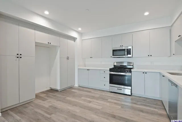 a kitchen with granite countertop white cabinets and stainless steel appliances