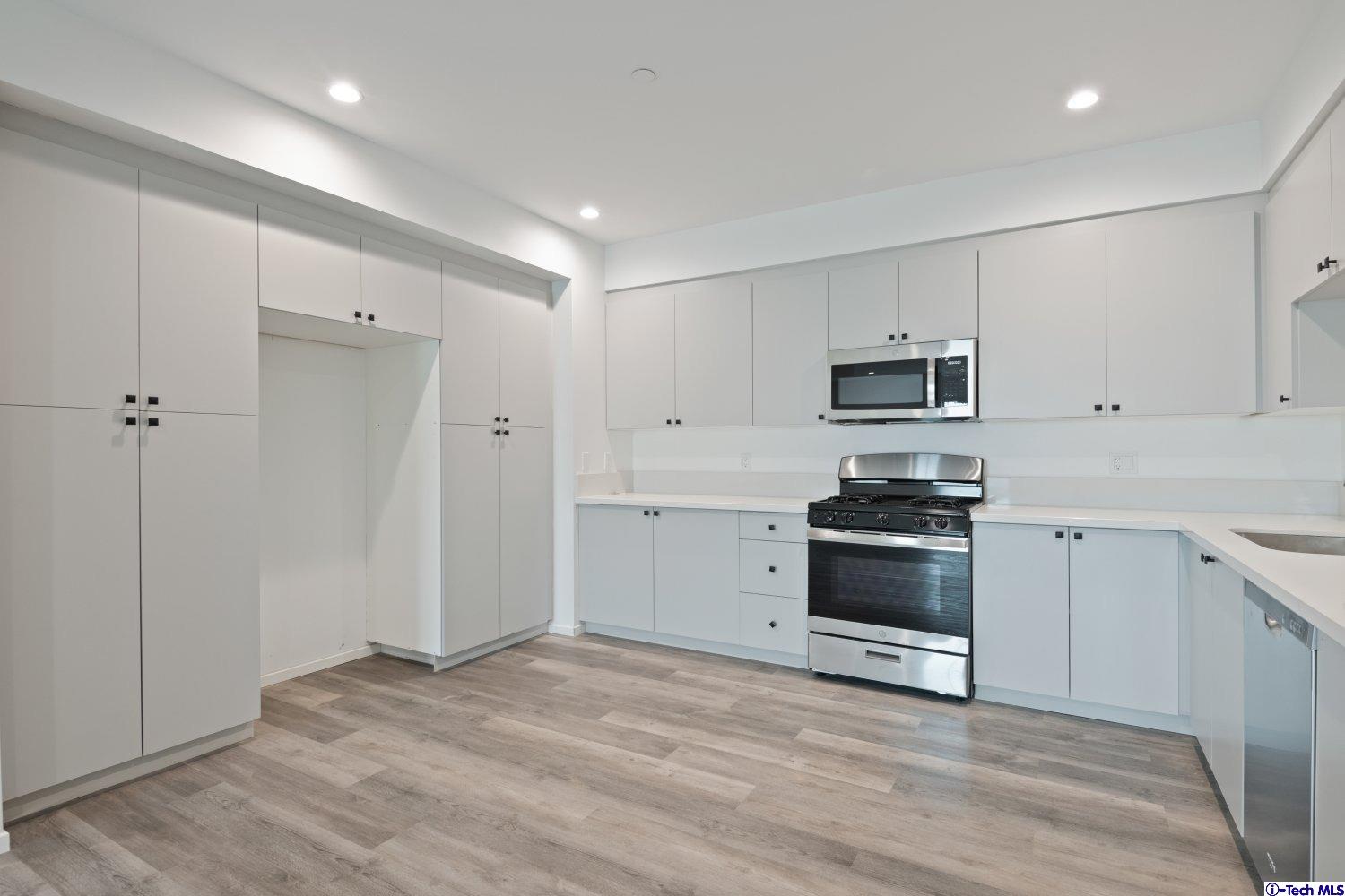 7064 Greeley Street, Unit 201 Tujunga, CA 91042 - Photo 16 of 34 a kitchen with cabinets stainless steel appliances and a counter space