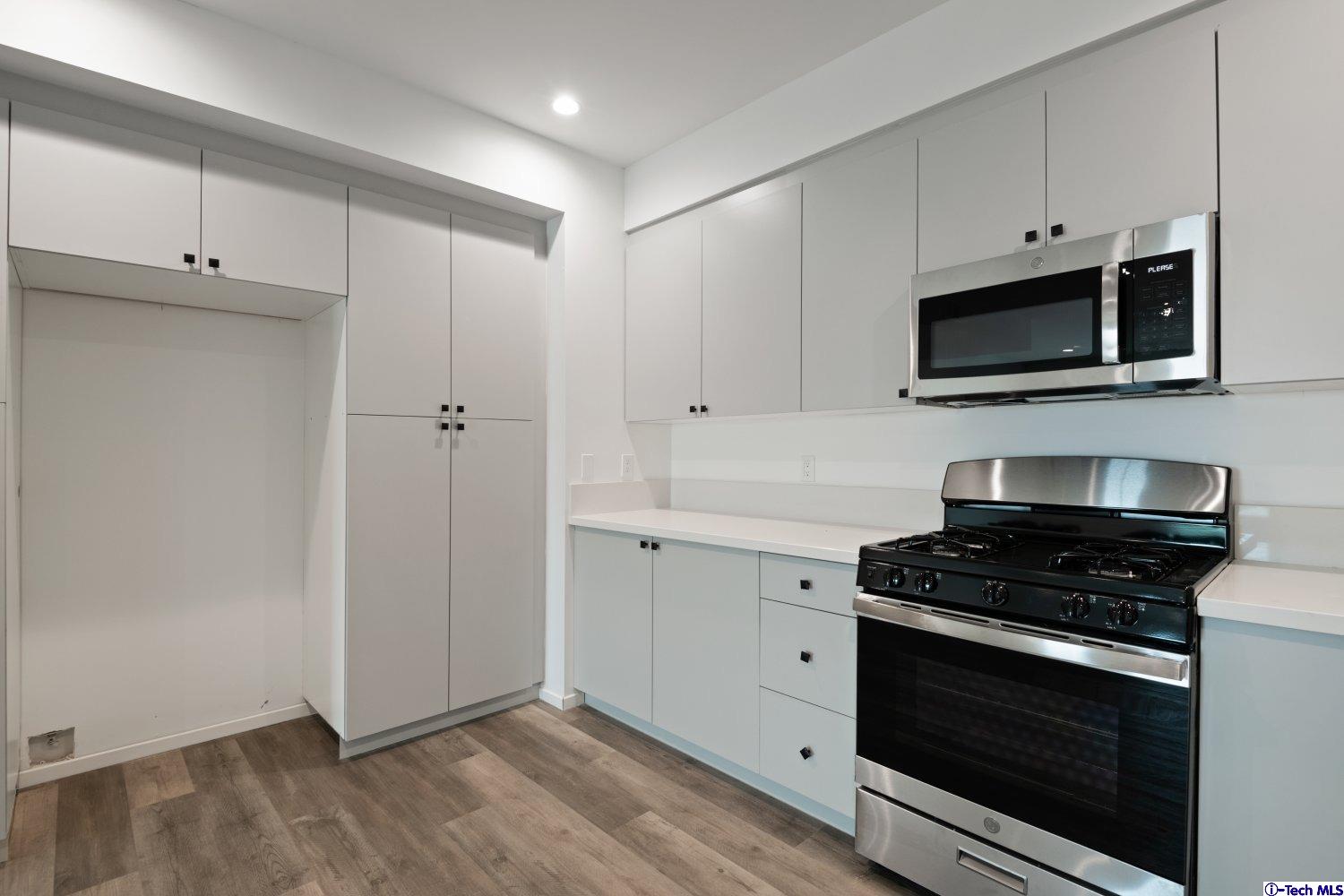 7064 Greeley Street, Unit 201 Tujunga, CA 91042 - Photo 17 of 34 a kitchen with cabinets stainless steel appliances and wooden floor