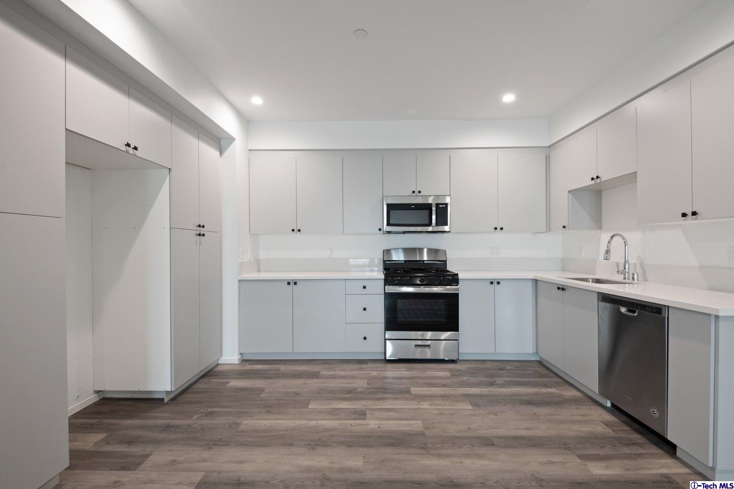 7064 Greeley Street, Unit 201 Tujunga, CA 91042 - Photo 18 of 34 a kitchen with granite countertop white cabinets and stainless steel appliances