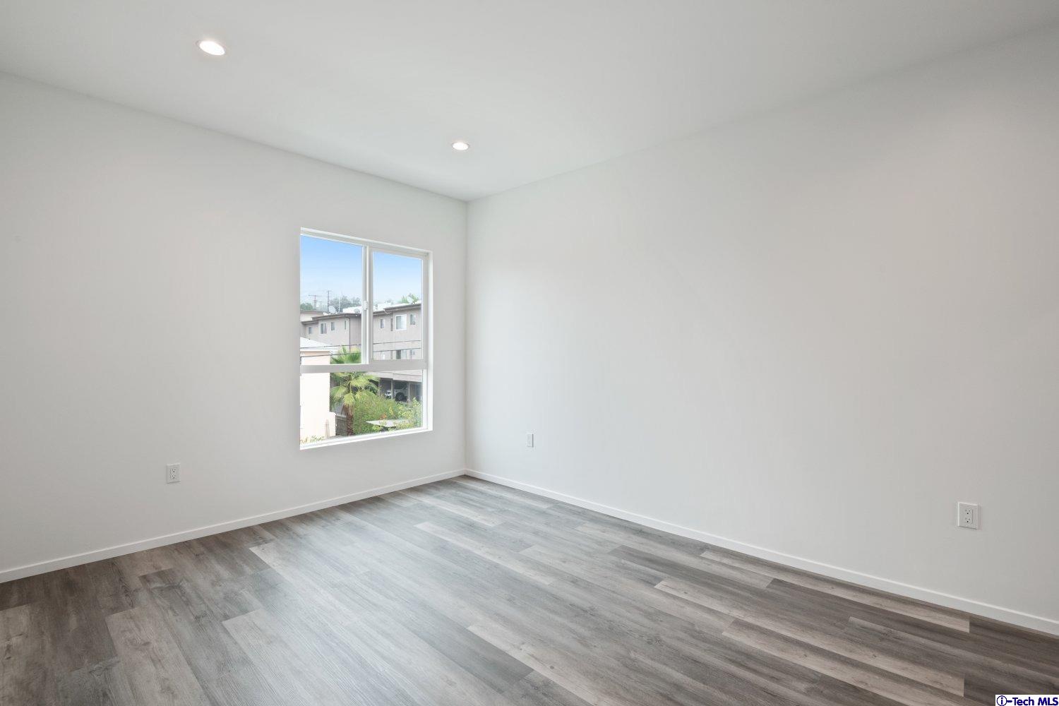 7064 Greeley Street, Unit 201 Tujunga, CA 91042 - Photo 24 of 34 an empty room with wooden floor and windows