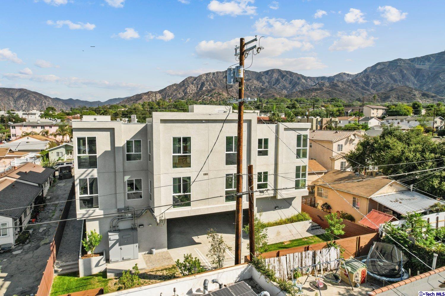 7064 Greeley Street, Unit 201 Tujunga, CA 91042 - Photo 34 of 34 a front view of a building with a garden and lake view