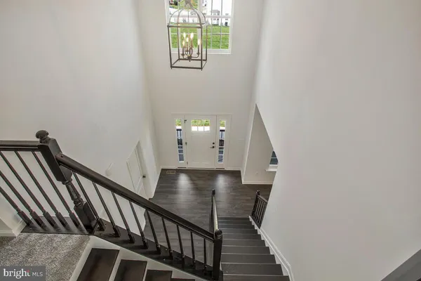 a view of staircase with wooden floor and white walls