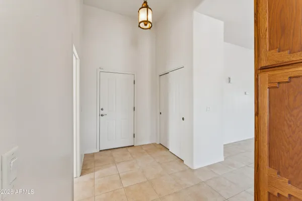 wooden floor in an empty room with a chandelier fan