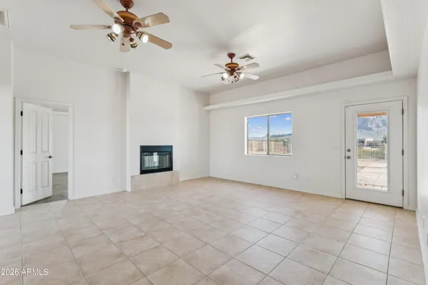 an empty room with windows and fan