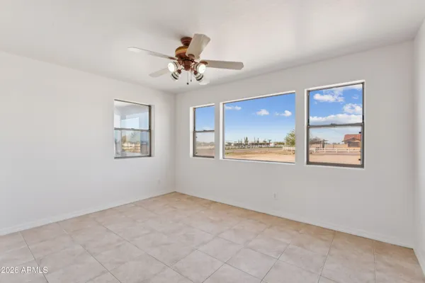 a view of a livingroom with a fan & a window