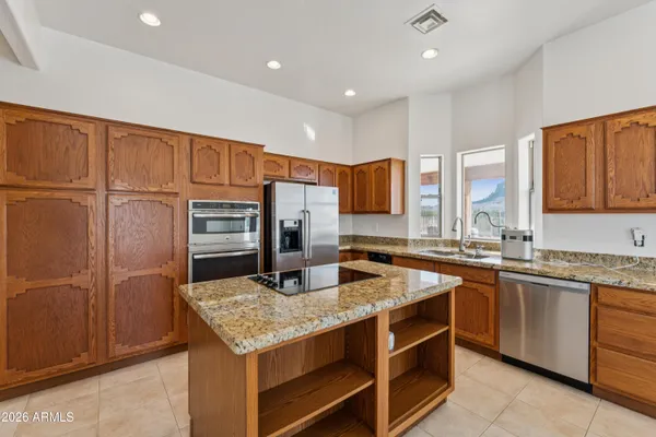 a kitchen with stainless steel appliances granite countertop a sink a stove and a refrigerator