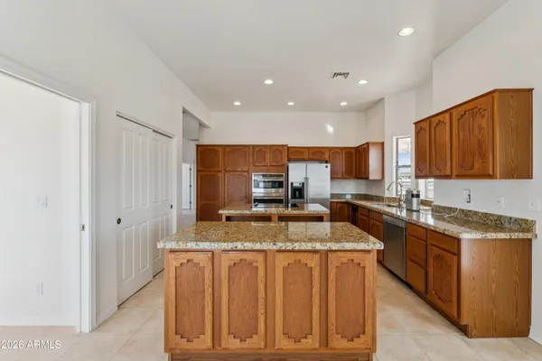 a kitchen with granite countertop a sink a counter top space and cabinets