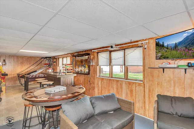 a living room with furniture a table and a large window