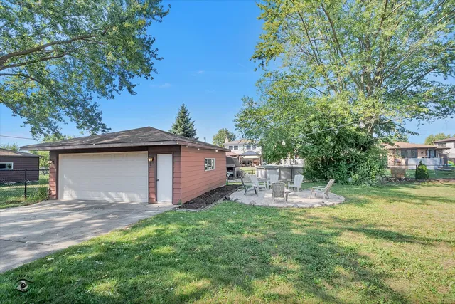 a view of a chair and table in backyard of the house