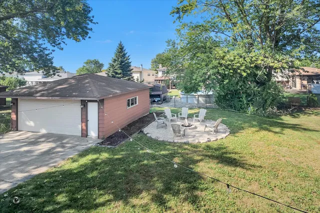 a view of a patio with table and chairs potted plants and large tree