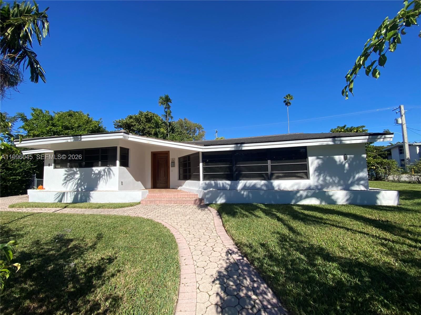 1101 Bay Drive Miami Beach, FL 33141 - Photo 1 of 69 a front view of a house with garden