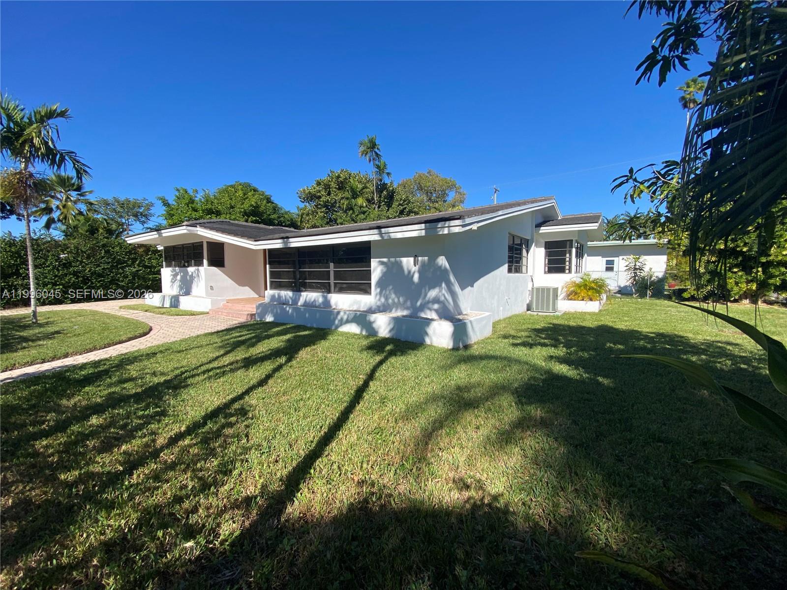 1101 Bay Drive Miami Beach, FL 33141 - Photo 2 of 69 a front view of a house with a yard table and chairs