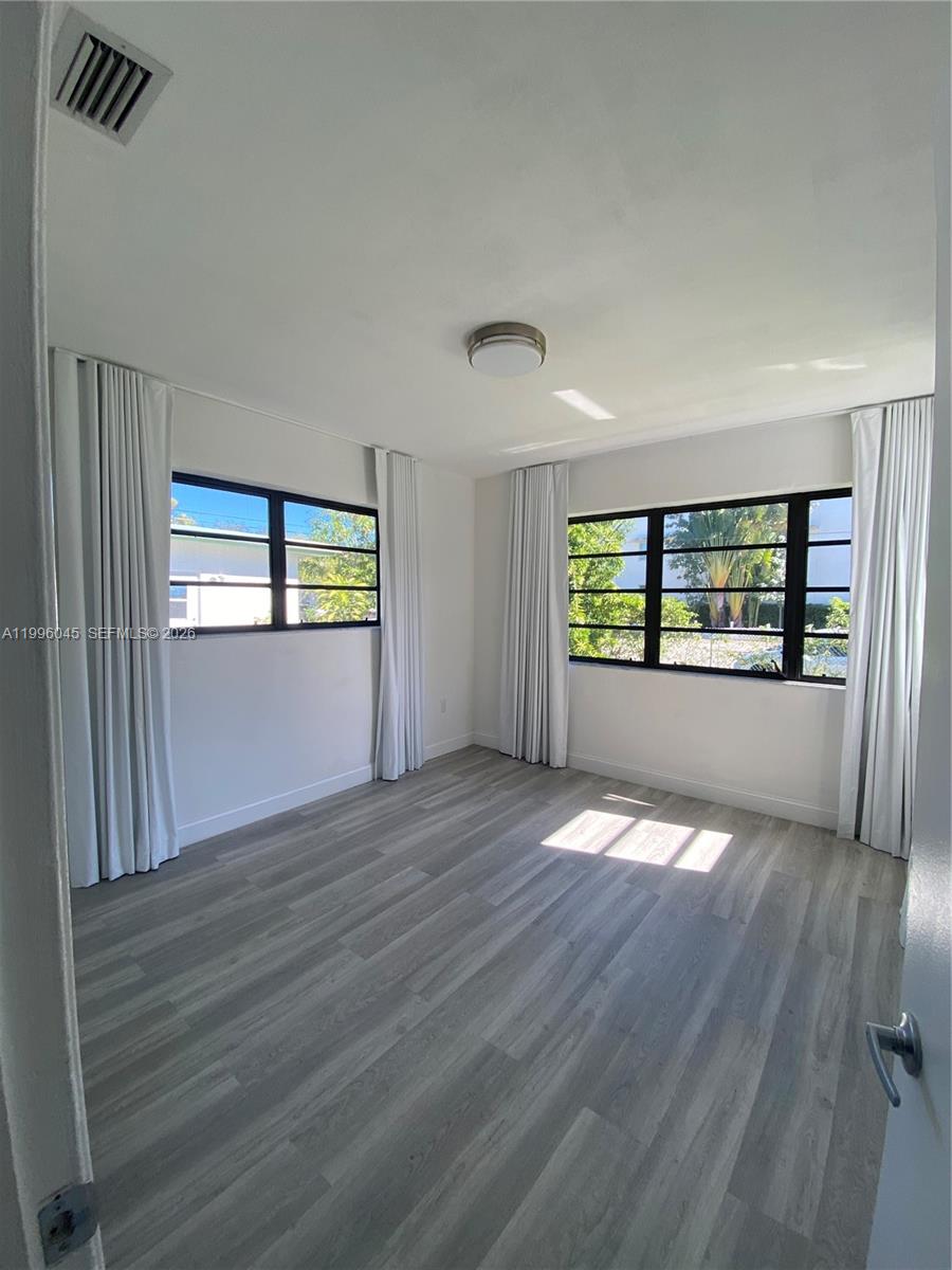 1101 Bay Drive Miami Beach, FL 33141 - Photo 38 of 69 a view of an empty room with a window and wooden floor
