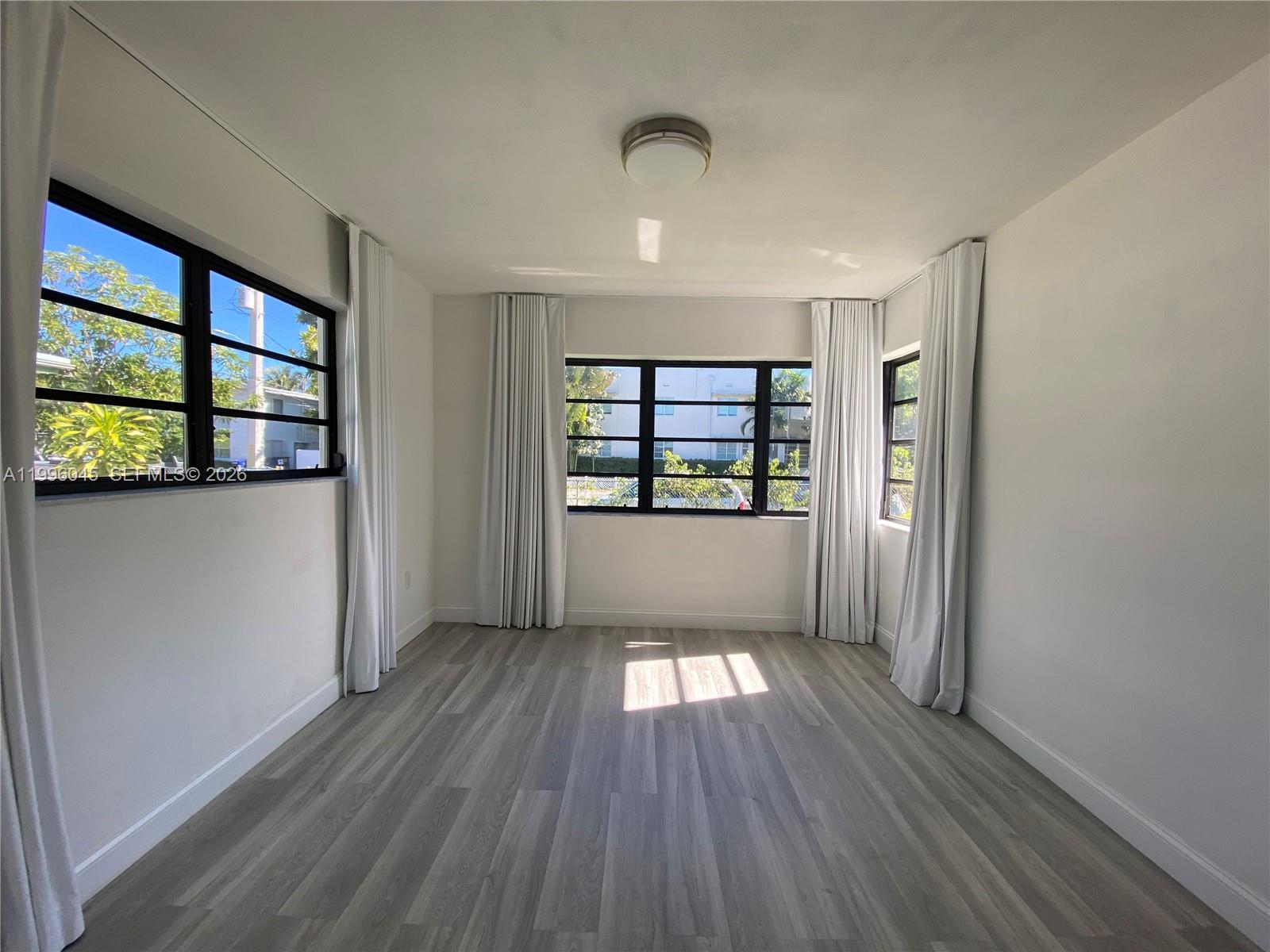 1101 Bay Drive Miami Beach, FL 33141 - Photo 40 of 69 wooden floor in an empty room with a window