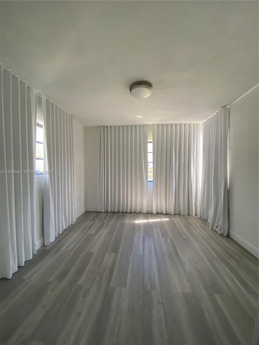 1101 Bay Drive Miami Beach, FL 33141 - Photo 42 of 69 an empty room with wooden floor and windows