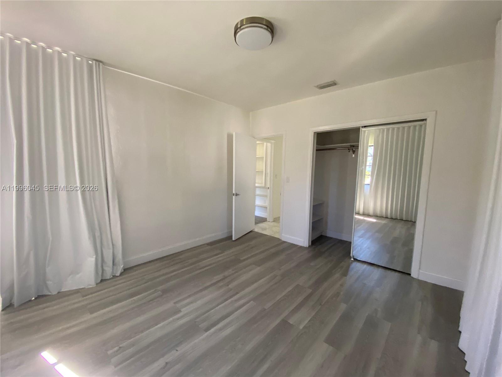 1101 Bay Drive Miami Beach, FL 33141 - Photo 45 of 69 an empty room with wooden floor and windows