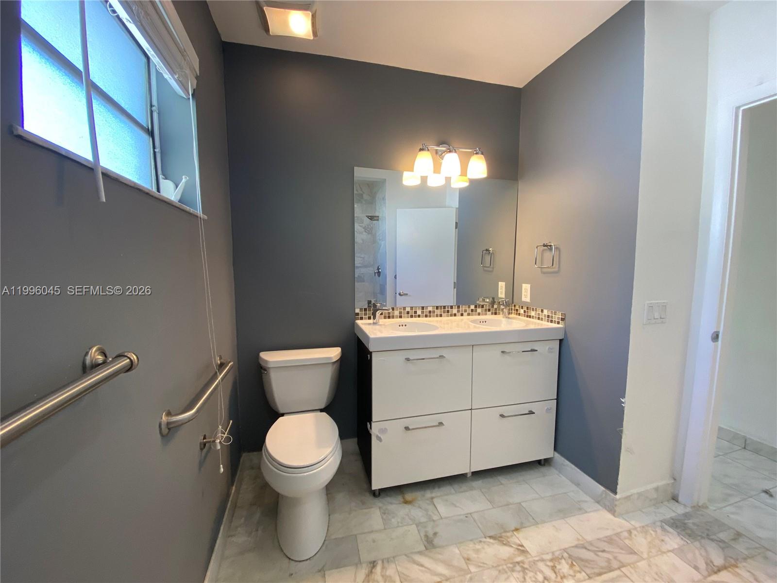 1101 Bay Drive Miami Beach, FL 33141 - Photo 50 of 69 a bathroom with a toilet a sink and a mirror