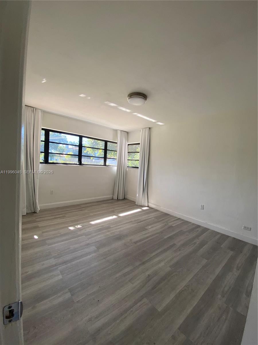 1101 Bay Drive Miami Beach, FL 33141 - Photo 56 of 69 an empty room with wooden floor and windows