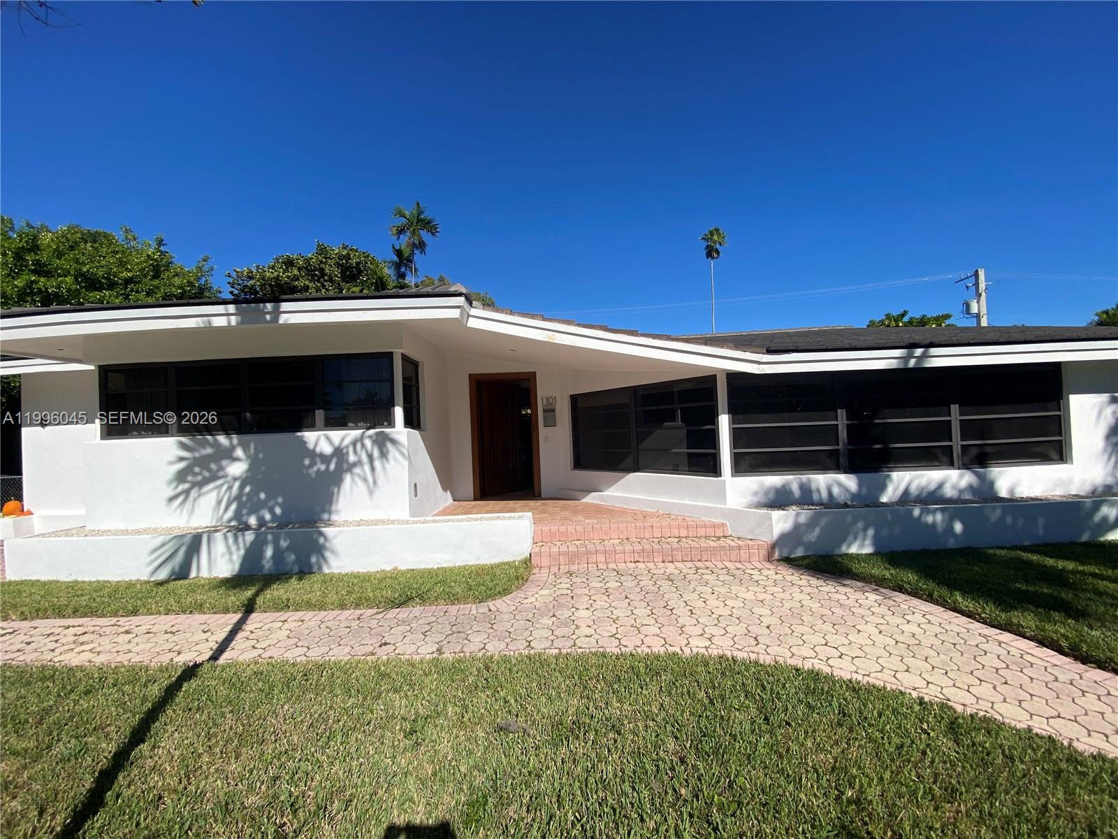 1101 Bay Drive Miami Beach, FL 33141 - Photo 7 of 69 a front view of a house with a yard and garage