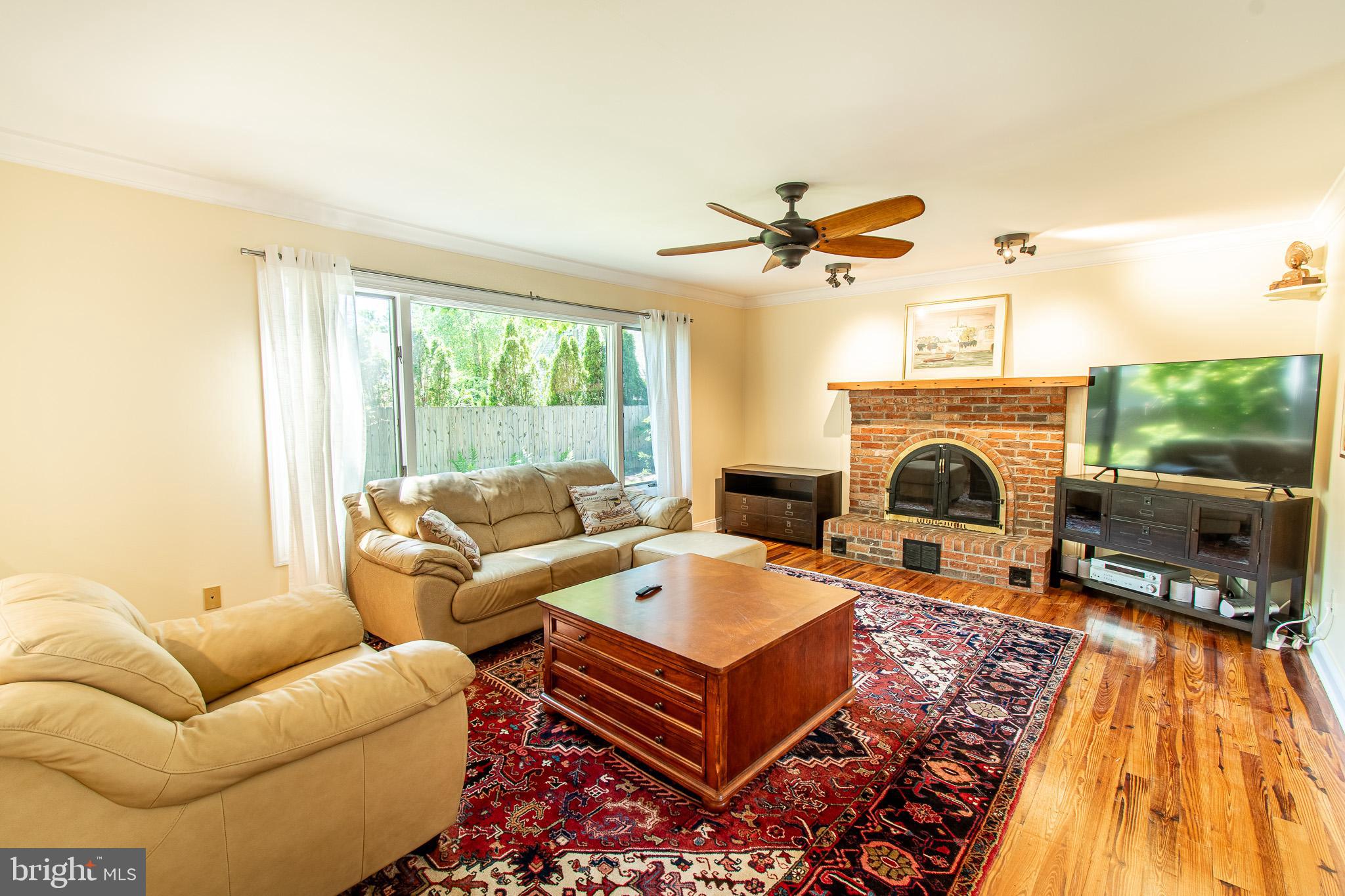 102 Jacks Point Road Oxford, MD 21654 - Photo 24 of 83 a living room with furniture a fireplace and a floor to ceiling window