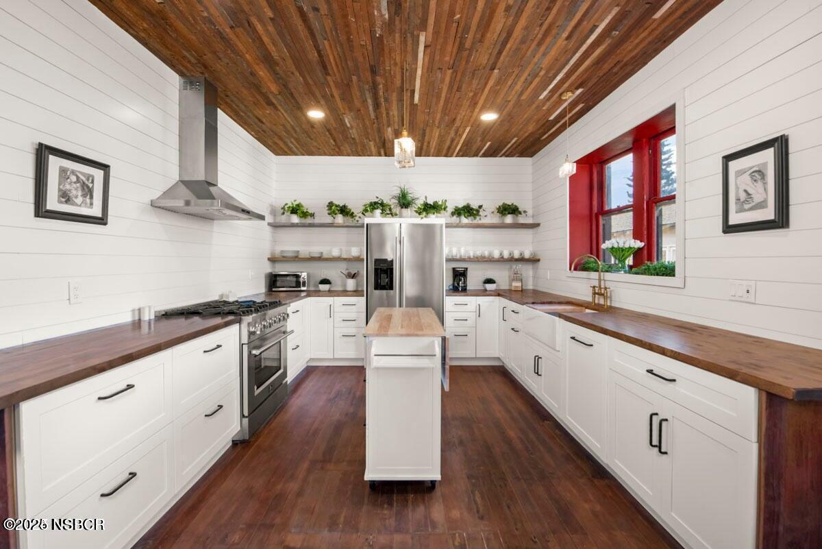 215 South H Street Lompoc, CA 93436 - Photo 6 of 24 a large kitchen with stainless steel appliances granite countertop a lot of counter space and wooden floors
