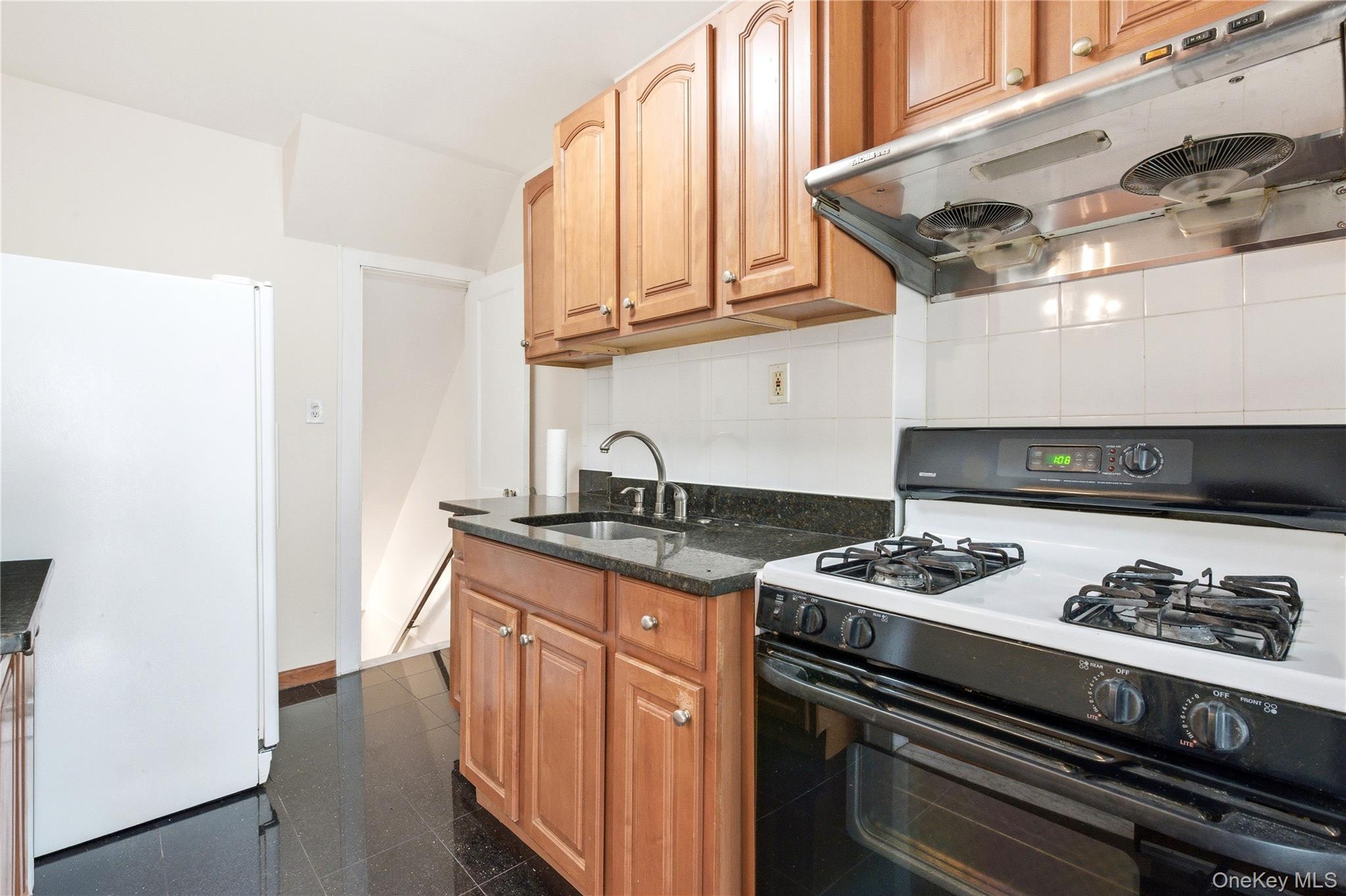 67-99 Exeter Street Queens, NY 11375 - Photo 12 of 28 a kitchen with stainless steel appliances granite countertop a stove and a sink