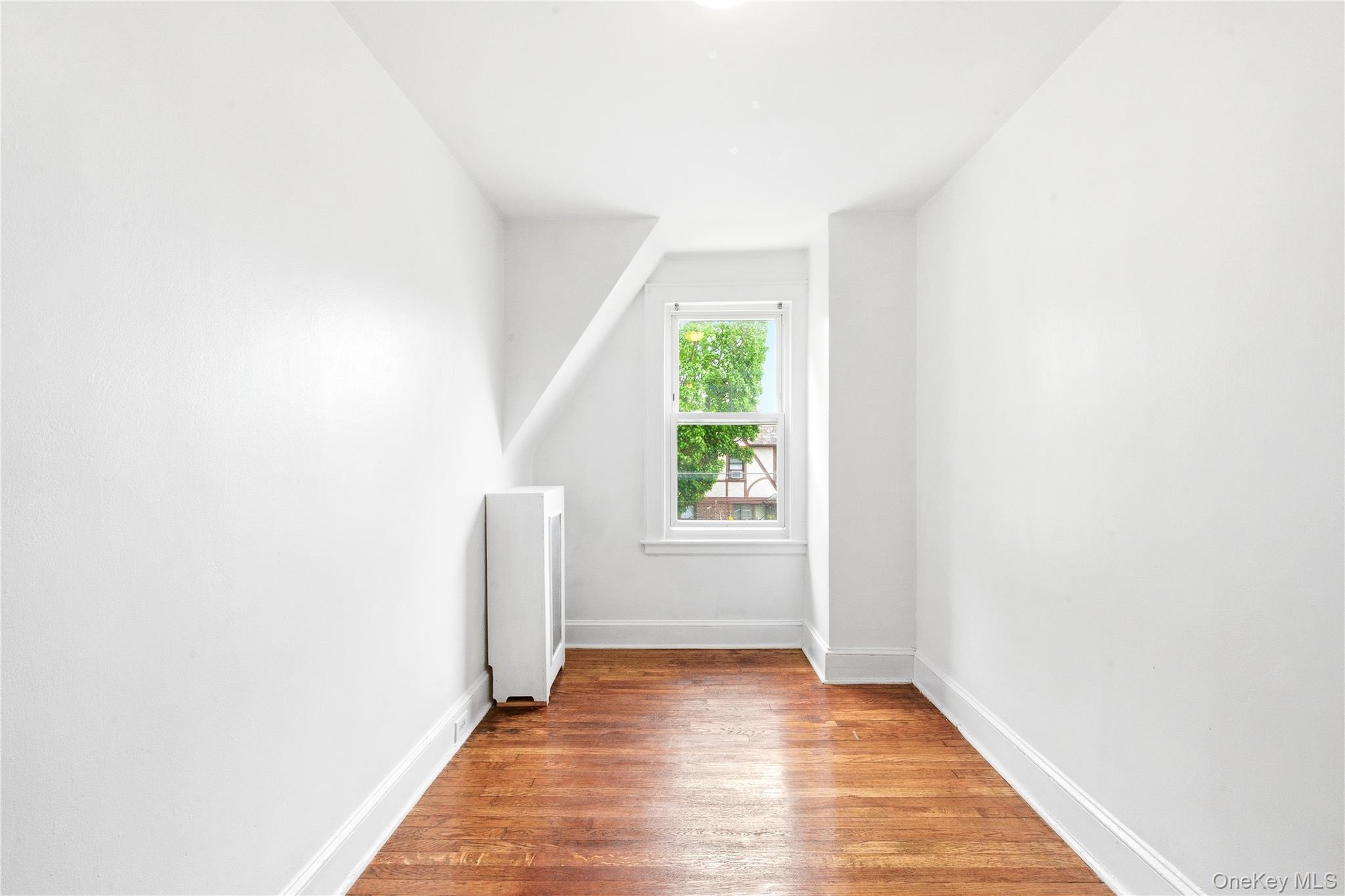 67-99 Exeter Street Queens, NY 11375 - Photo 19 of 28 a view of an empty room with wooden floor and a window