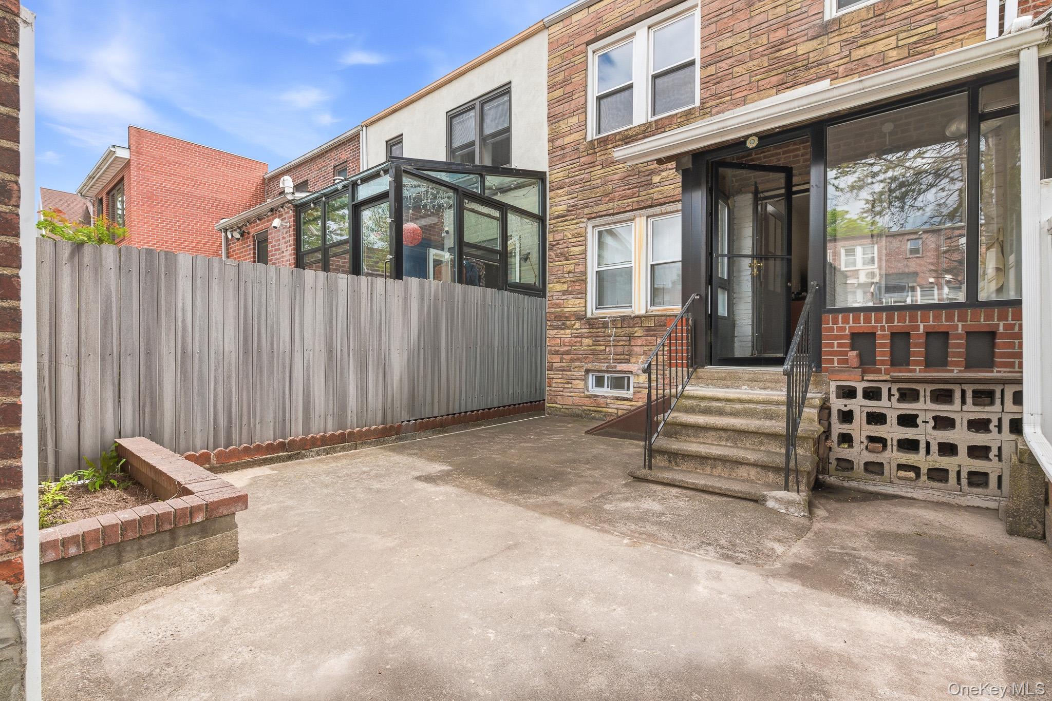 67-99 Exeter Street Queens, NY 11375 - Photo 26 of 28 a view of a blue house with a large window and wooden fence
