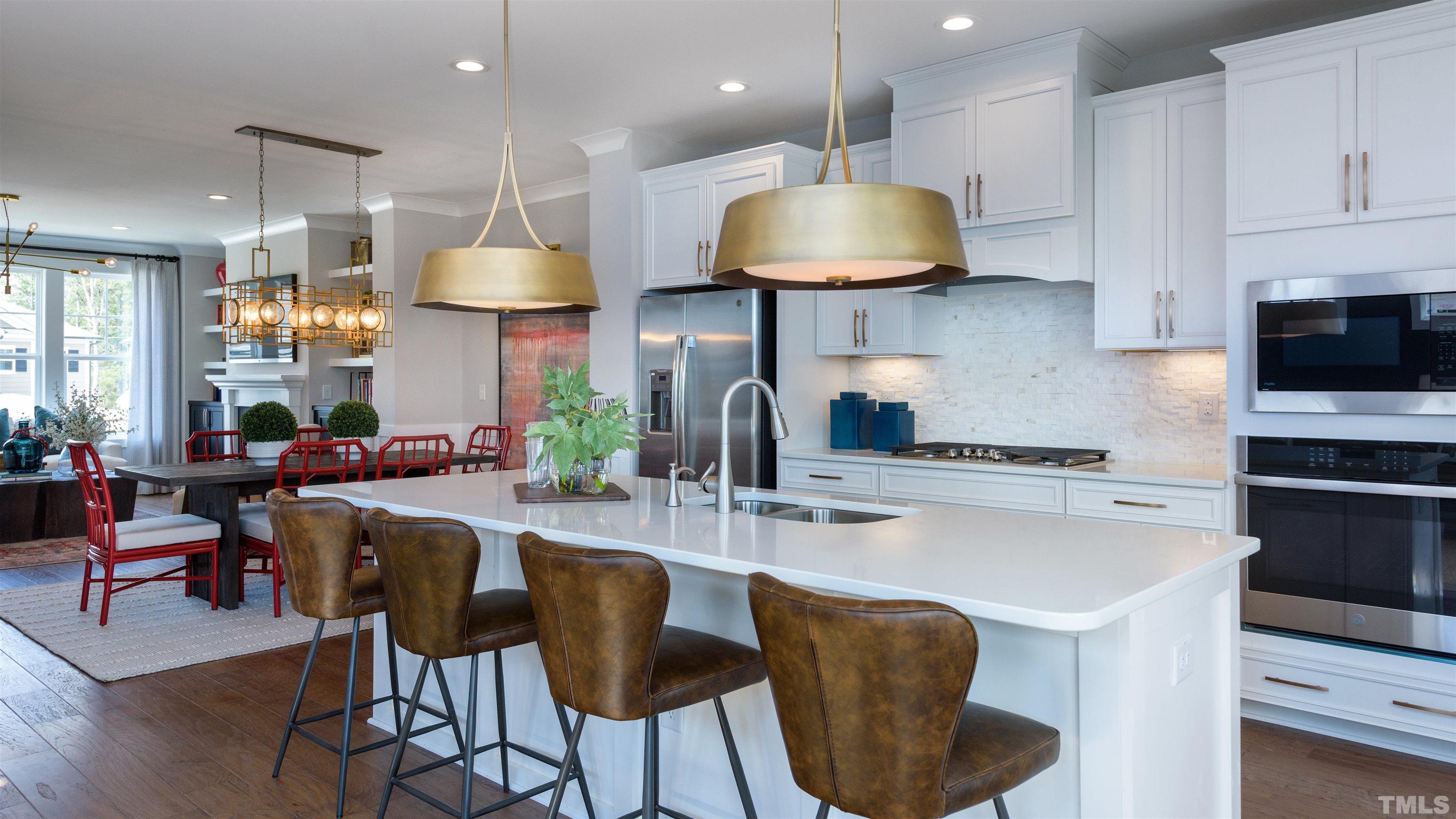 3255 Lynn Road, Unit 15 Raleigh, NC 27613 - Photo 18 of 21 a kitchen with stainless steel appliances granite countertop a stove a sink a microwave a dining table and chairs with wooden floor