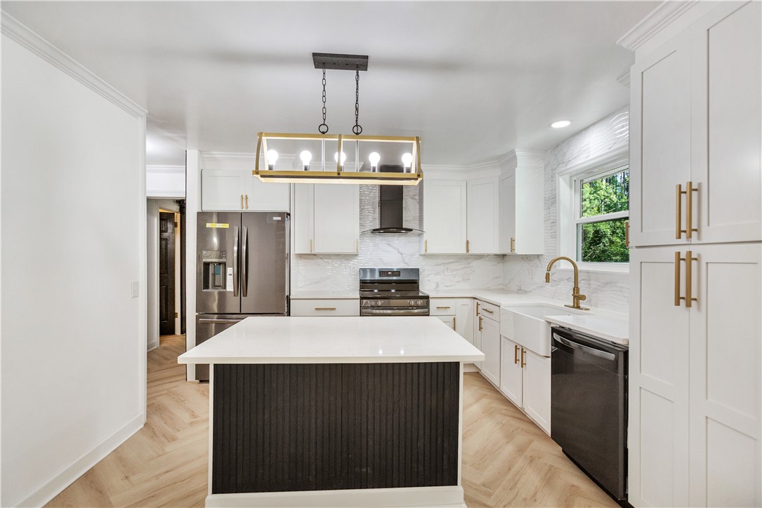 809 Paige Road Honea Path, SC 29654 - Photo 12 of 33 Modern kitchen featuring white shaker cabinetry, stainless steel appliances, a center island with a white countertop, light flooring, and gold-tone hardware