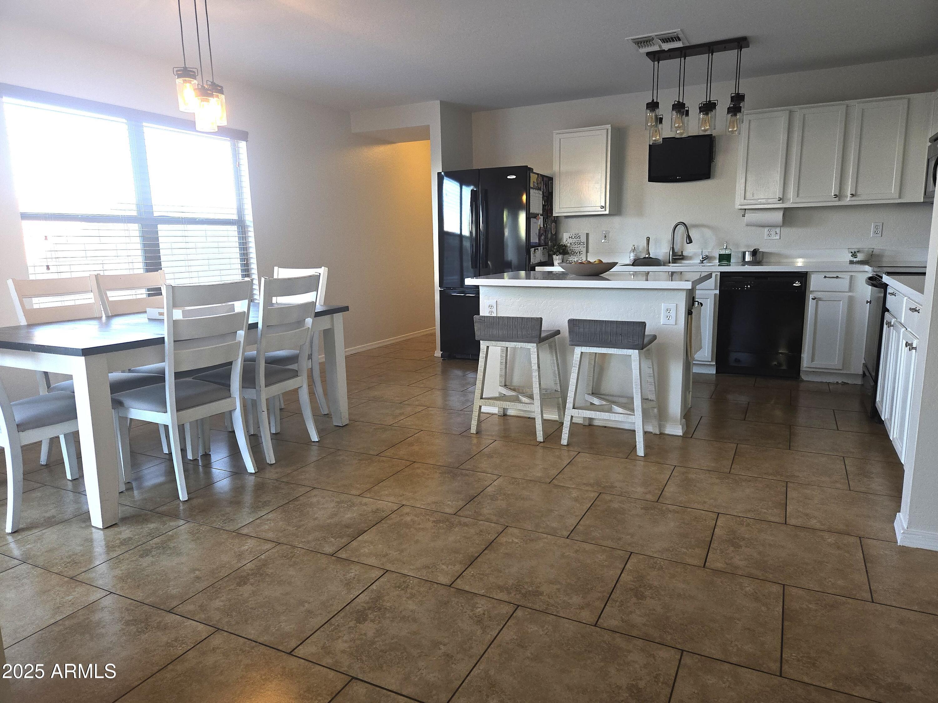 3283 South Conestoga Road Apache Junction, AZ 85119 - Photo 6 of 32 a kitchen with a sink dining table and chairs