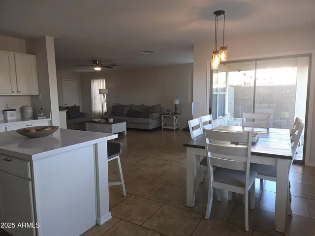 a kitchen with a dining table chairs and white cabinets