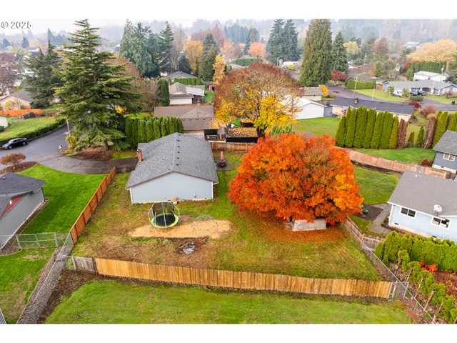 an aerial view of residential houses with outdoor space and parking