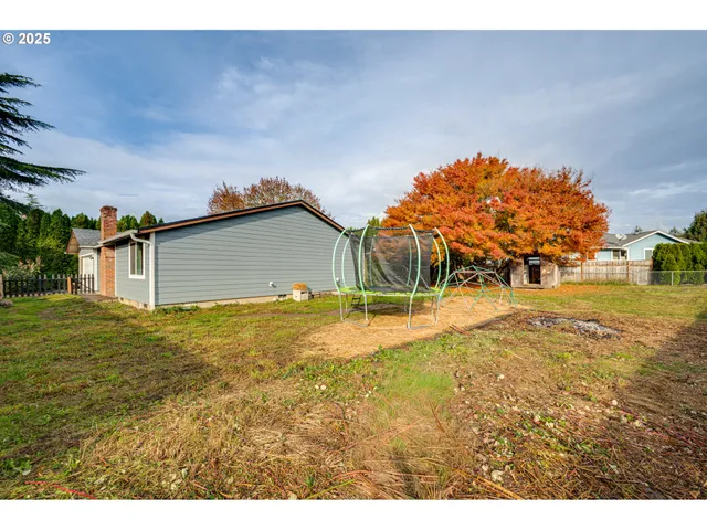 an aerial view of residential houses with outdoor space and trees