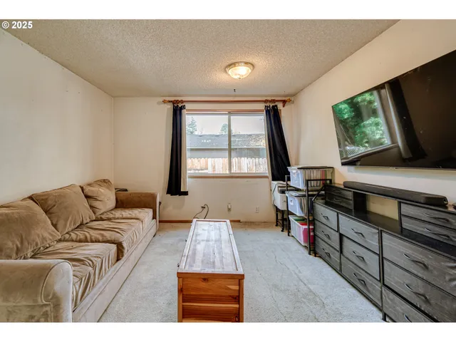 a living room with furniture a flat screen tv and a window