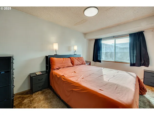 a bedroom with a bed and a large window