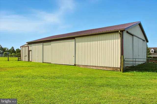a aerial view of a house with pool a yard and lake view