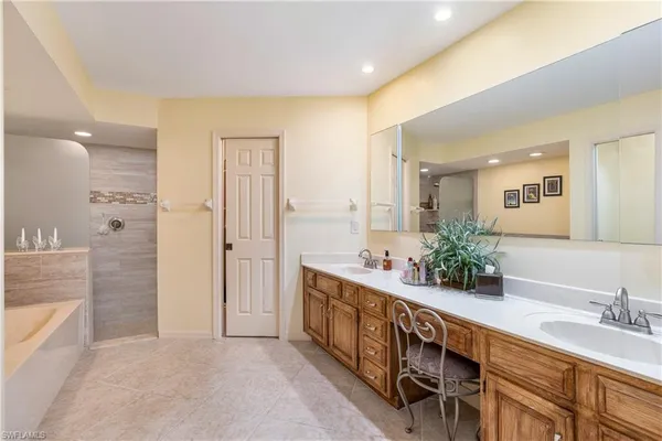 a spacious bathroom with double vanity and a mirror